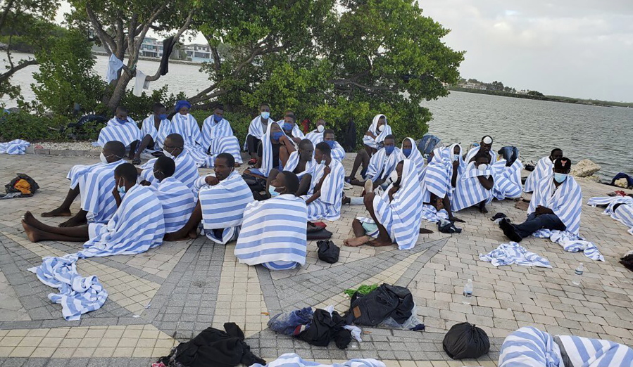 FILE - This photo provided by the United States Border Patrol shows Haitian migrants on shore wrapped in towels after a boat ran aground in the Florida Keys off Key Largo on Sunday, March 6, 2022.  Haitian migrants are reaching Florida's shores in a string of suspected smuggling operations that could outpace last year's migration waves.
