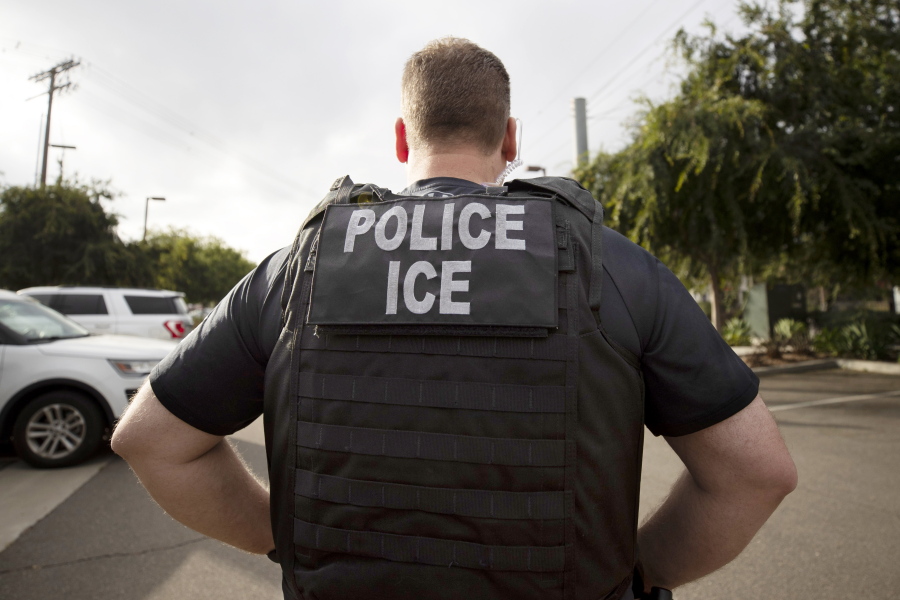 FILE - A U.S. Immigration and Customs Enforcement (ICE) officer looks on during an operation in Escondido, Calif.,  July 8, 2019.  Immigration enforcement arrests in the interior of the U.S. fell over the past year as the Biden administration shifted its enforcement focus to people in the country without legal status who have committed serious crimes.
