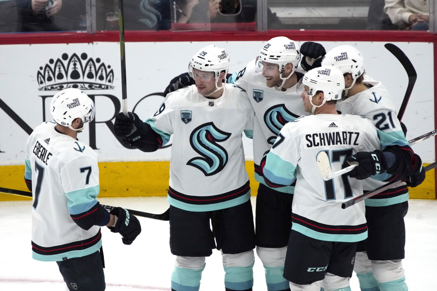 Seattle Kraken defenseman Carson Soucy, center, celebrates with right wing Jordan Eberle (7), defenseman Vince Dunn (29), center Alex Wennberg (21), and center Jaden Schwartz (17) after scoring a goal against the Arizona Coyotes during the second period of an NHL hockey game Tuesday, March 22, 2022, in Glendale, Ariz.