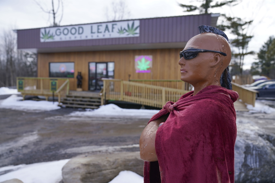 A statue of a Mohawk warrior is displayed in front of the Good Leaf Dispensary on the reservation Mohawks call Akwesasne, Monday, March 14, 2022, in St. Regis, N.Y.  As New York inches toward launching an adult marijuana market, sales are flourishing on some Native American territory in the state. Shops selling buds and edibles dot the main road through the U.S. side of St. Regis Mohawk Reservation by the Canadian border.