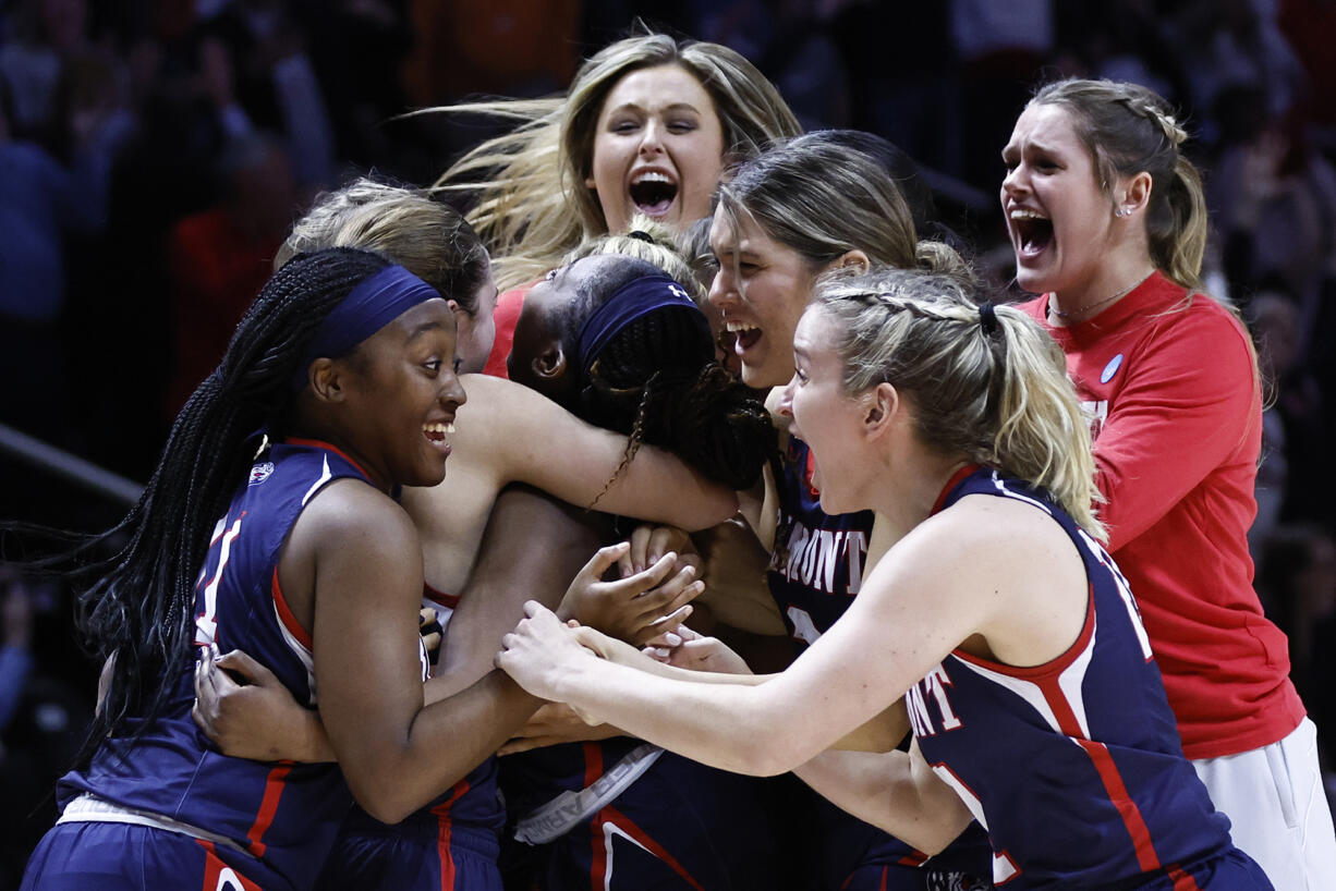Belmont players mob Tuti Jones, center, after a double-overtime win in a college basketball game against Oregon in the first round of the NCAA Tournament, Saturday, March 19, 2022, in Knoxville, Tenn.