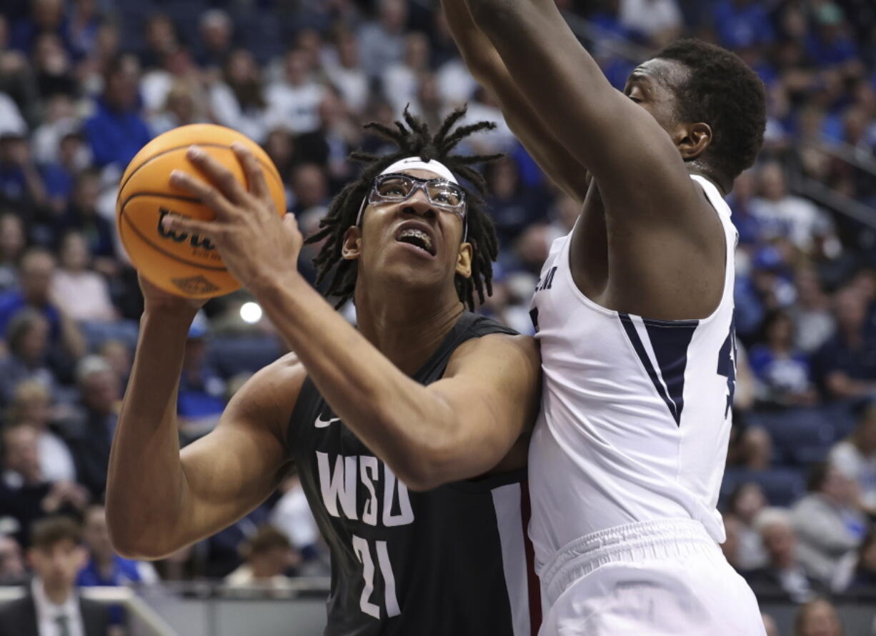 Washington State center Dishon Jackson (21) goes up for a shot with BYU forward Fousseyni Traore (45) defending during an NCAA college basketball game in the quarterfinals of the NIT, Wednesday, March 23, 2022, in Provo, Utah.