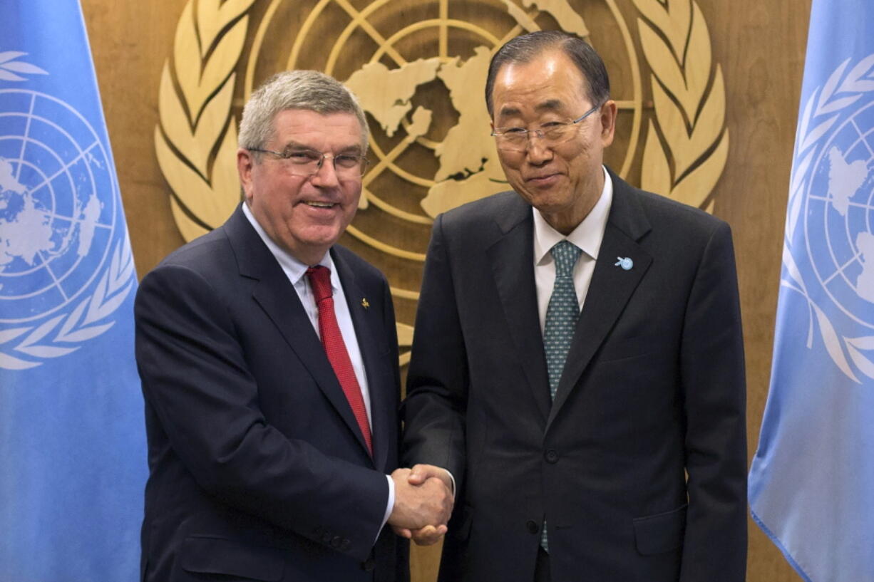 FILE - International Olympic Committee President Thomas Bach, left, shakes hands with United Nations Secretary-General Ban Ki-moon during a meeting at the United Nations headquarters Sunday, Sept. 27, 2015. The International Olympic Committee has always been political, from the sheikhs and royals in its membership to a seat at the United Nations to pushing for peace talks between the Koreas.