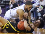 Washington guard Terrell Brown Jr., top, vies for a loose ball with Oregon guard Will Richardson, bottom, during the first half of an NCAA college basketball game Thursday, March 3, 2022, in Seattle. (AP Photo/Ted S.