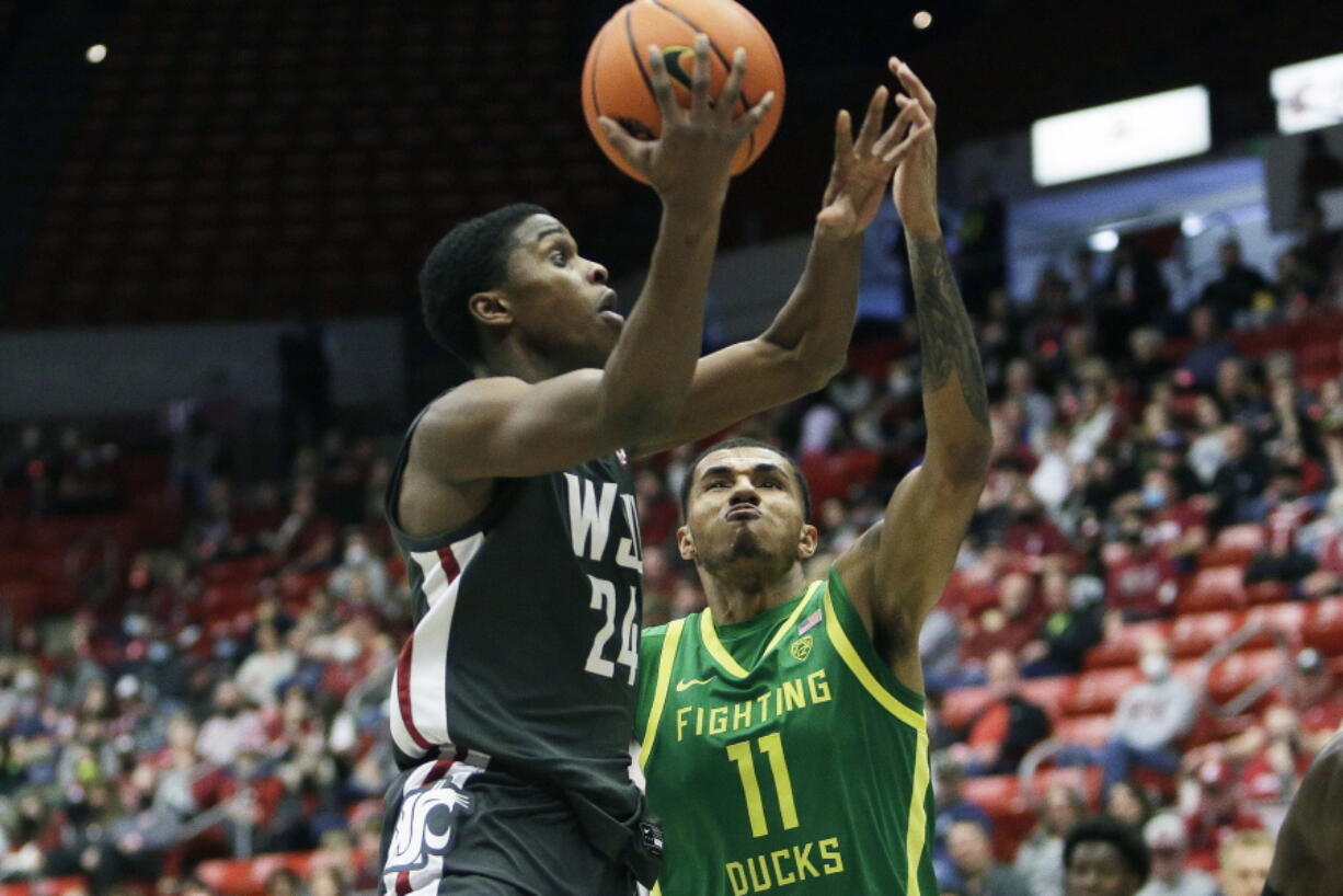 Washington State guard Noah Williams (24) drives to the basket while defended by Oregon guard Rivaldo Soares (11) during the second half of an NCAA college basketball game, Saturday, March 5, 2022, in Pullman, Wash. Washington State won 94-74.