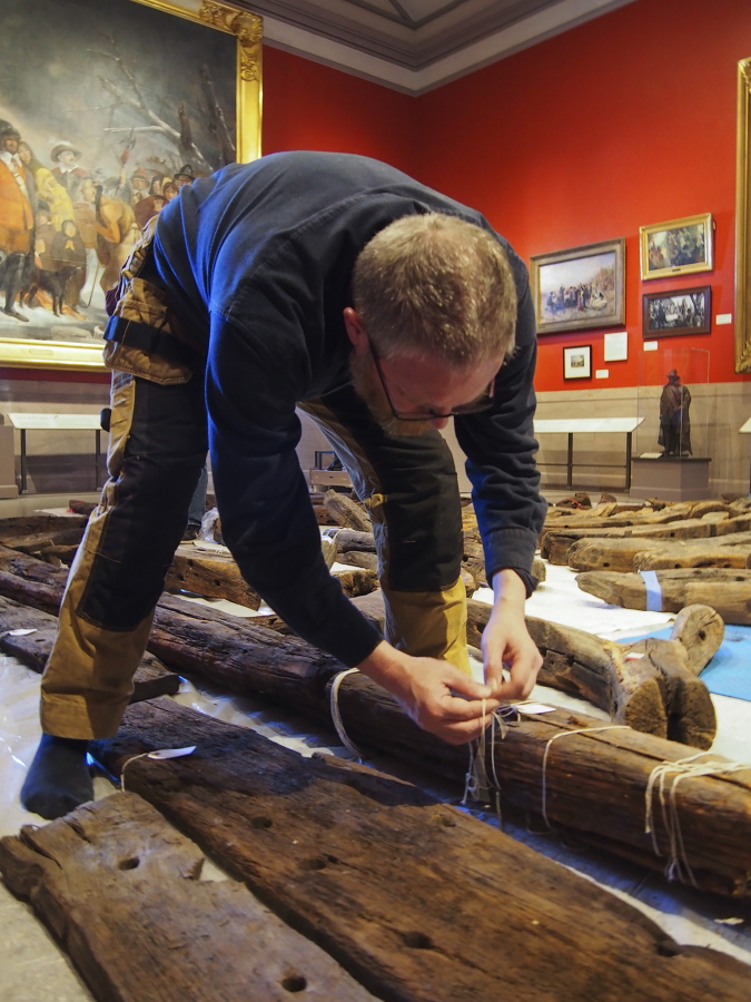 In this Jan. 2018 photo provided by the Pilgrim Hall Museum, Dr. Fred Hocker, Director of Research, Vasa Museum, Stockholm, Sweden, examines Sparrow-hawk timbers at Pilgrim Hall Museum, in Plymouth, Mass. The timbers were sampled in 2018 and analyzed over the course of several years.