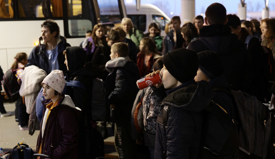 Ukrainian orphans are seen during a stopover in Warsaw as they are en route to the UK, in Warsaw, Poland, on Monday March 21, 2022. A UK-based group Dnipro Kids is helping the nearly 50 children get refugee in the UK until the Russia's war against Ukraine is over. They were supposed to fly on Monday but got stuck in Warsaw due to a paperwork issue.