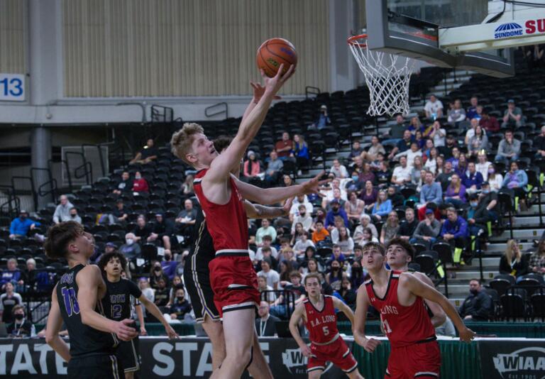 R.A. Long's Aaron Ofstun flips in a layup during the first half of the Class 2A boys state third-place game on Saturday at Yakima Valley SunDome.