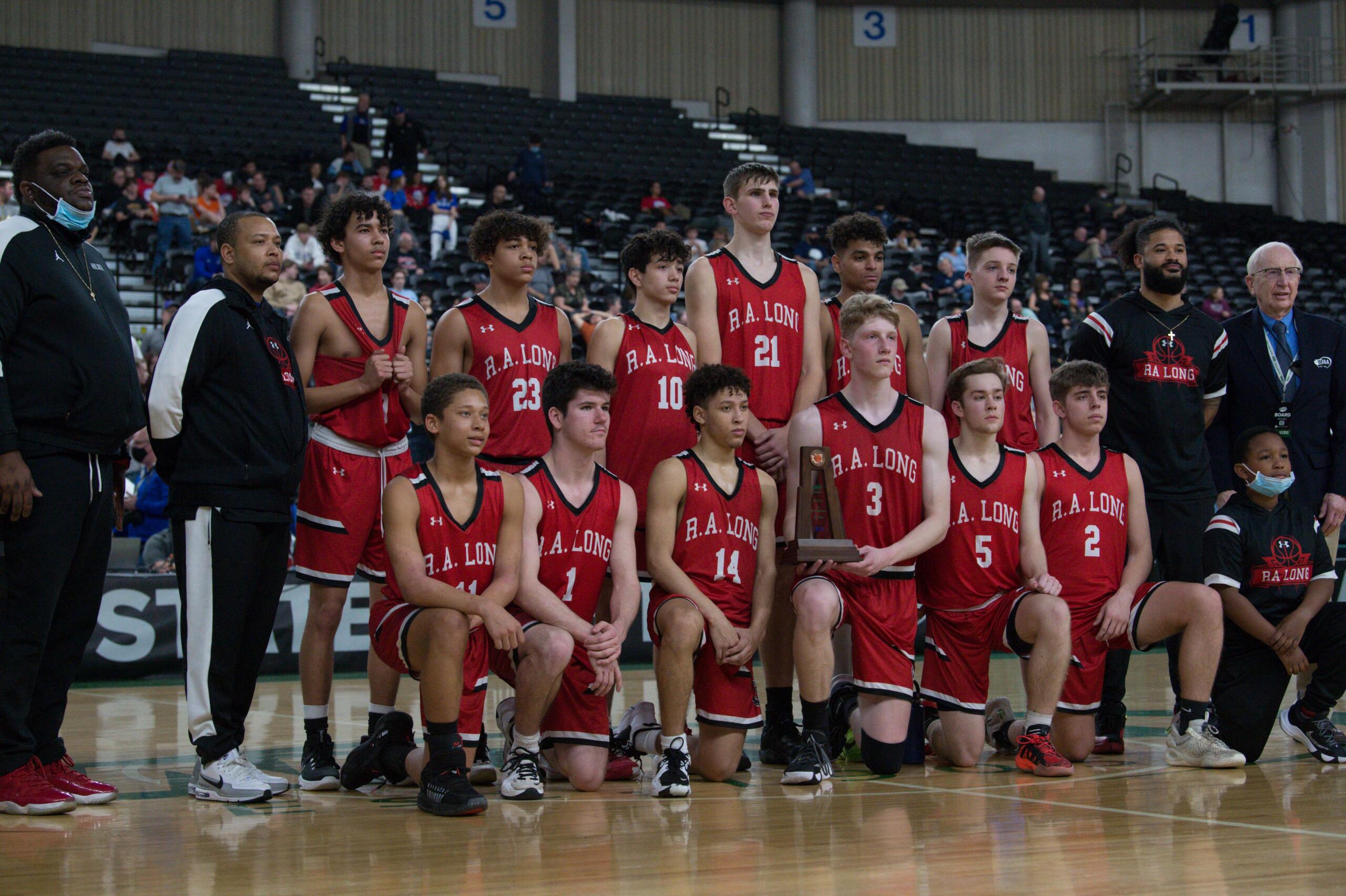 R.A. Long poses for a photo with the Class 2A boys state fifth-place trophy, marking the Lumberjacks' best finish at state since the 1950s, on Saturday at the Yakima Valley SunDome.