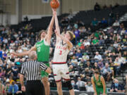 Tumwater's Ryan Otton (22) and R.A. Long's Aaron Ofstun vie for the opening tip at the state of a Class 2A state boys basketball quarterfinal game on Thursday in Yakima.