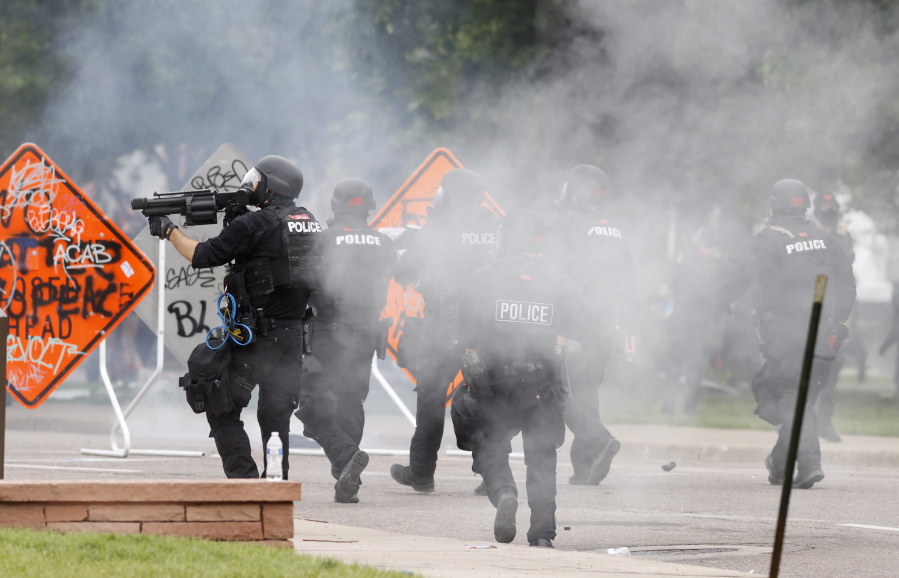 File -- Denver Police fire tear gas canisters during a protest outside the State Capitol over the death of George Floyd, in this file photograph taken on Saturday, May 30, 2020, in Denver. A civil lawsuit accusing the Denver Police Department of using indiscriminate force against people protesting the killing of Floyd is set to go on trial Monday, March 7, 2022, in federal court.