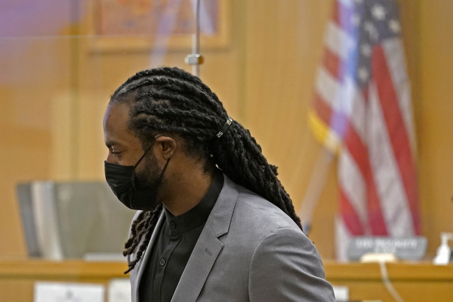 FILE - Richard Sherman stands up to leave a King County District Court hearing, Friday, July 16, 2021, in Seattle. Sherman, now with the Tampa Bay buccaneers, pleaded guilty Monday to two misdemeanor charges stemming from a drunken driving and domestic disturbance last summer as part of an agreement that spares him further jail time. (AP Photo/Ted S.
