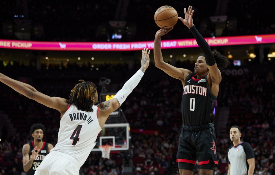 Houston Rockets guard Jalen Green, right, shoots over Portland Trail Blazers forward Greg Brown III during the second half of an NBA basketball game in Portland, Ore., Friday, March 25, 2022.