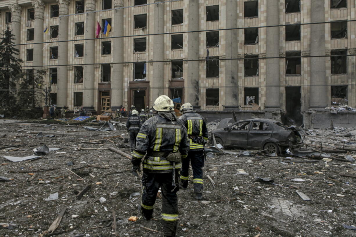 Ukrainian emergency service personnel work outside the damaged City Hall building following shelling, in Kharkiv, Ukraine, Tuesday, March 1, 2022. Russia on Tuesday stepped up shelling of Kharkiv, Ukraine's second-largest city, pounding civilian targets there. Casualties mounted and reports emerged that more than 70 Ukrainian soldiers were killed after Russian artillery recently hit a military base in Okhtyrka, a city between Kharkiv and Kyiv, the capital.
