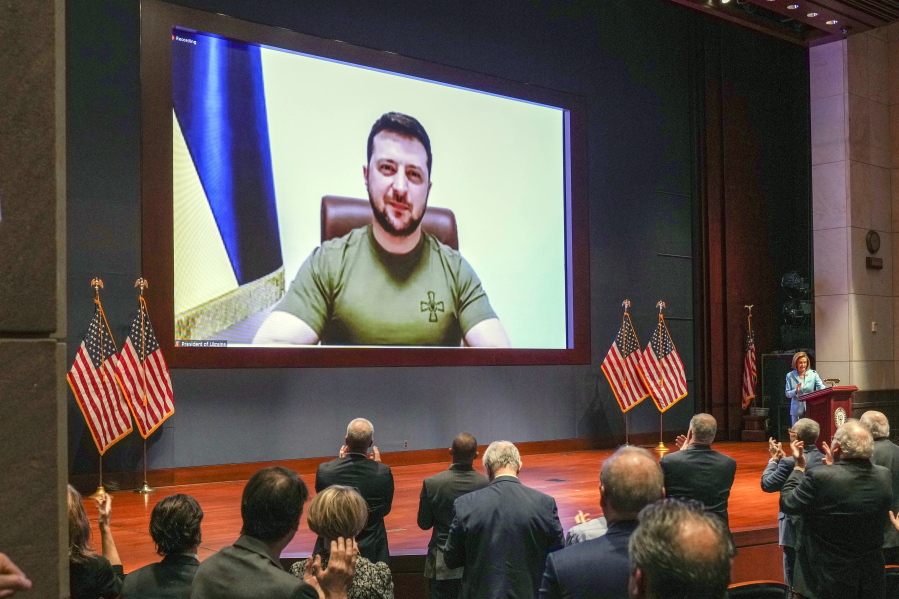 FILE - Members of Congress give Ukraine President Volodymyr Zelensky a standing ovation before he speaks in a virtual address to Congress in the U.S. Capitol Visitors Center Congressional Auditorium in Washington, on Wednesday, March 16, 2022. Ukraine, which has waged a staunch defense against Russian invasion, says it has pioneered a new source of financial support: People around the world who have donated millions of dollars directly to its war effort via cryptocurrencies such as bitcoin.