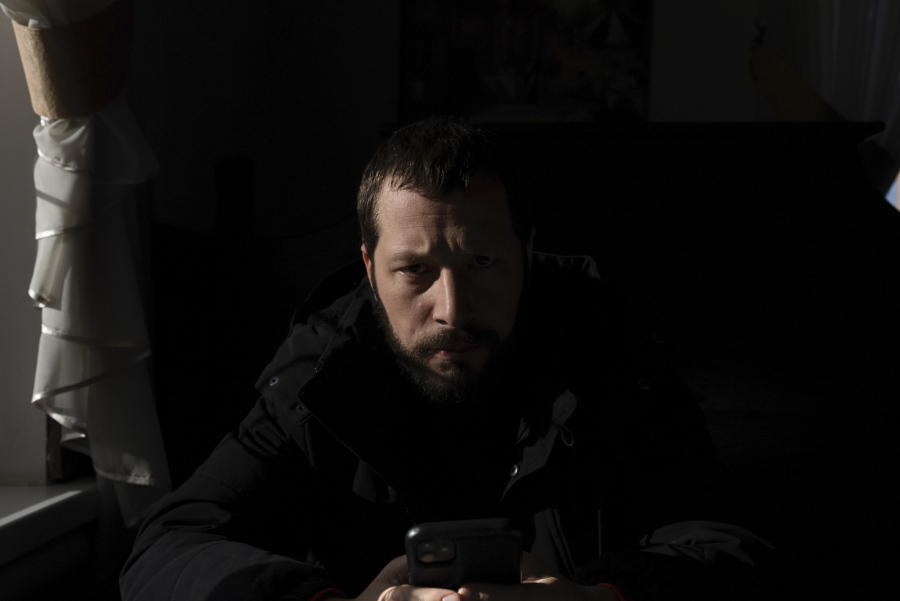 Associated Press videographer Mstyslav Chernov reads news on his phone three days before the start of Russian invasion in Volnovakha, Ukraine, Monday, Feb. 21, 2022. On the evening of Feb. 23, Chernov headed to Mariupol with colleague Evgeniy Maloletka.