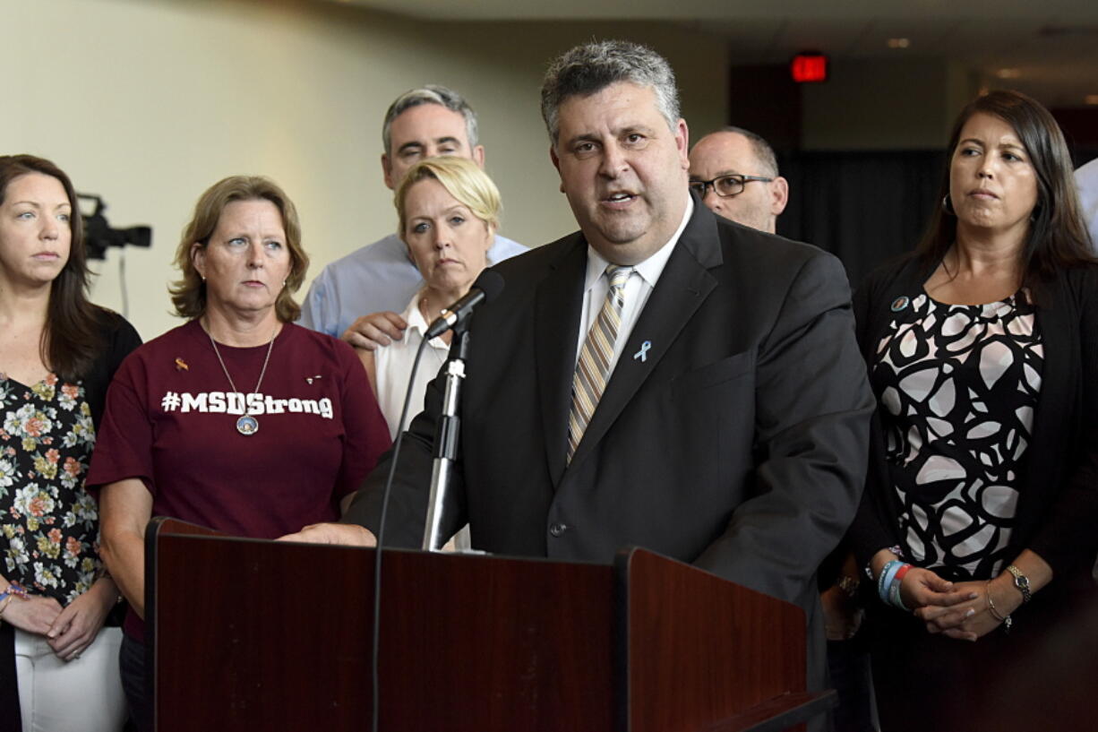 FILE- In this Aug. 9, 2018, file photo, Tony Montalto, father of Gina Rose, a victim of the Marjory Stoneman Douglas High School shooting, speaks during a news conference in Sunrise, Fla. Montalto, whose 14-year-old daughter Gina was killed, is president of "Stand with Parkland," a group composed of parents and spouses of the victims. Montalto is surrounded by other family members of those killed. Parents of victims in Florida's 2018 high school massacre say they are glad to see the federal government reach a $127.5 million settlement over FBI inaction in the case, and hope a future tragedy can be prevented.