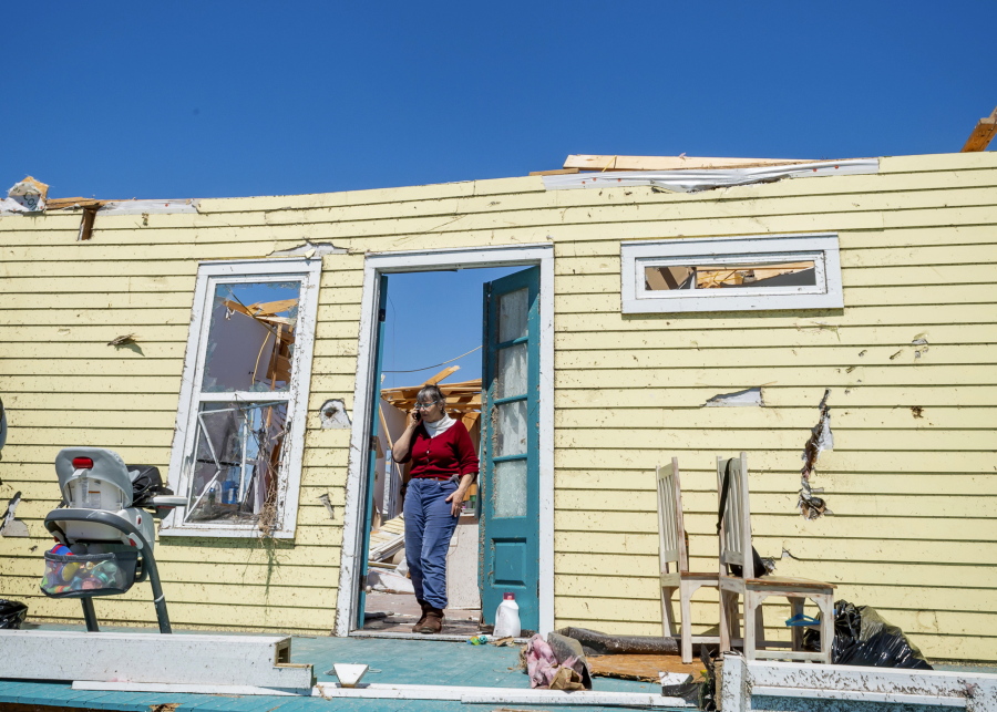 A woman stands in the doorway of a severely damaged home Wednesday in Arabi, La.