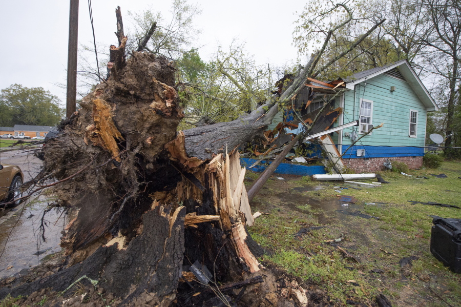 A house on Summer Street, just north of Winter Street, in Jackson, Miss., was heavily damaged by a downed tree during severe weather that moved through the city Wednesday, March 30, 2022.(Barbara Gauntt/The Clarion-Ledger via AP)