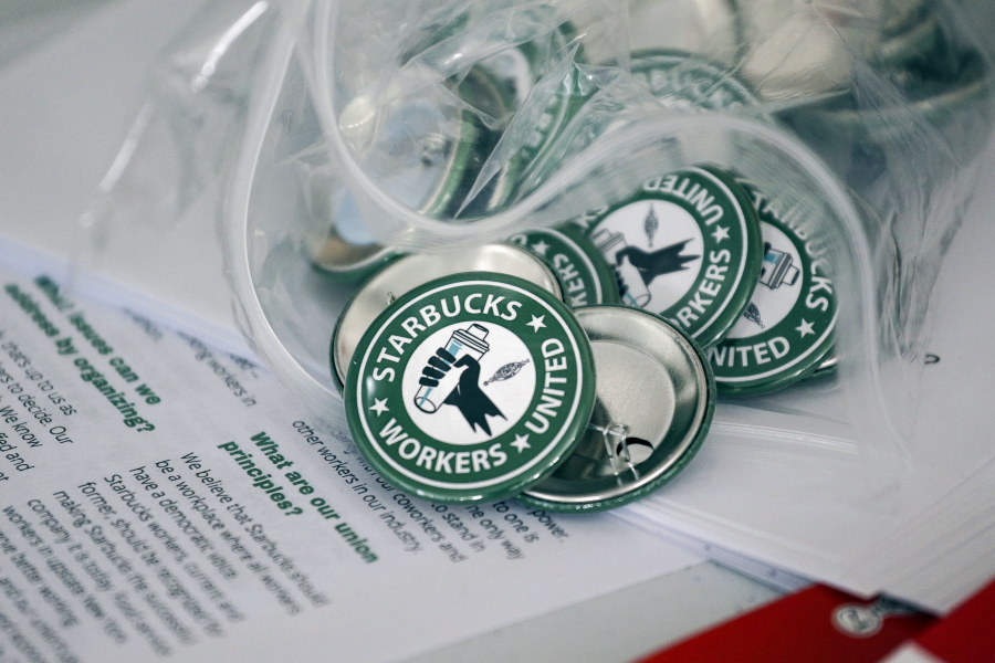 FILE -- Pro-union pins sit on a table during a watch party for Starbucks' employees union election, Dec. 9, 2021, in Buffalo, N.Y. Workers at a Seattle Starbucks store in the city's Capitol Hill neighborhood are set to vote on unionization on Tuesday, March 22, 2022, the latest push by workers at the coffee giant to form collective bargaining units.