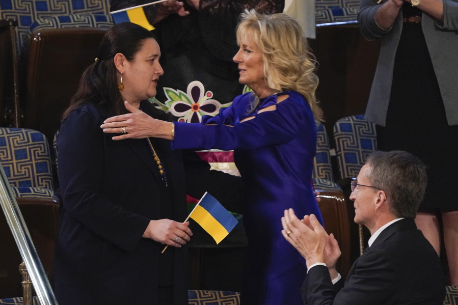 Ukraine Ambassador to the United States, Oksana Markarova, gets a hug from first lady Jill Biden during President Joe Biden's first State of the Union address to a joint session of Congress, at the Capitol in Washington, Tuesday, March 1, 2022. Patrick Gelsinger, CEO of Intel, applauds at front right. (AP Photo/J.