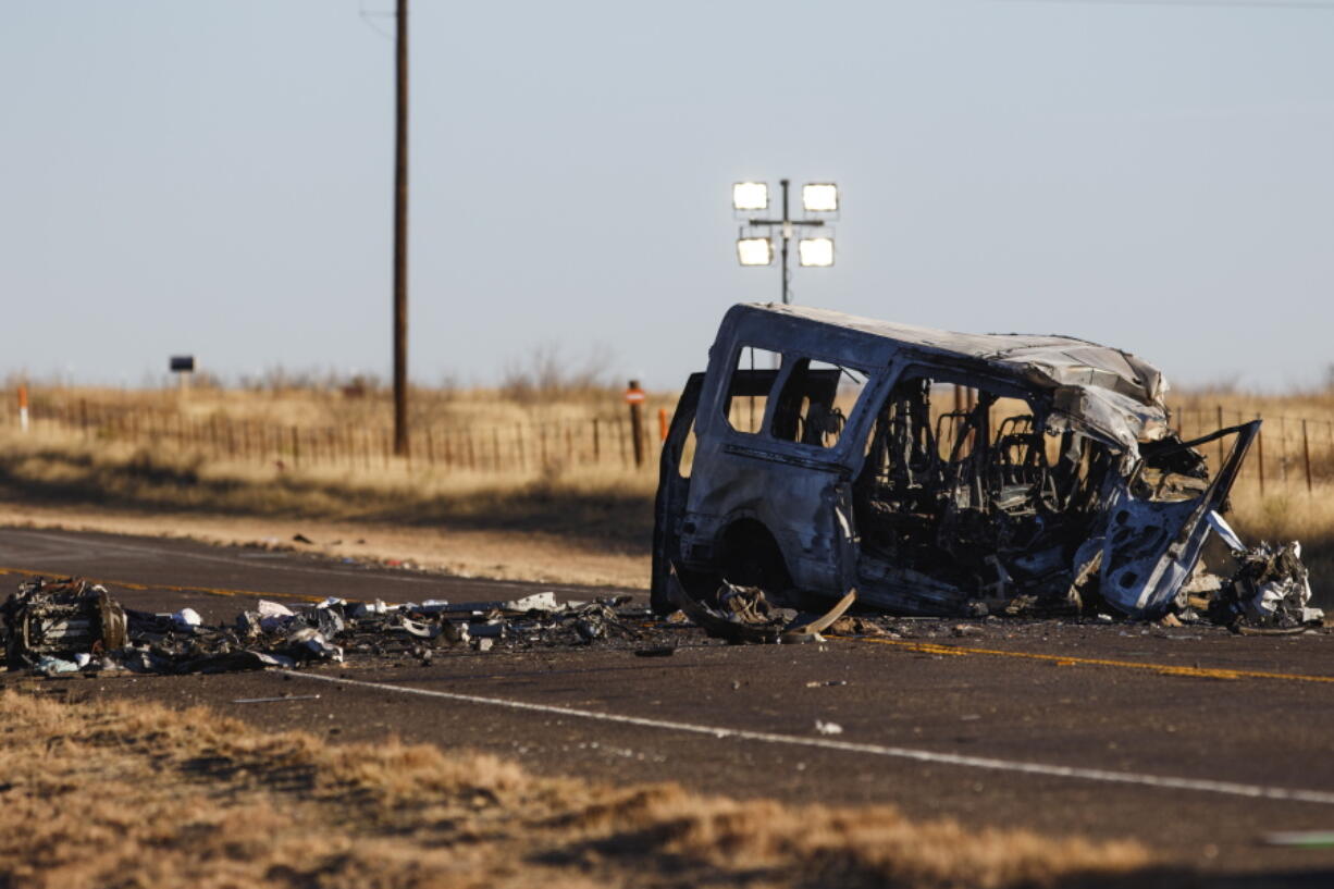 The damage bus sits on the side of the road at the scene of a fatal car wreck early Wednesday, March 16, 2022 half of a mile north of State Highway 115 on Farm-to-Market Road 1788 in Andrews County, Texas. A pickup truck crossed the center line of a two-lane road in Andrews County, about 30 miles (50 kilometers) east of the New Mexico state line on Tuesday evening and crashed into a van carrying members of the University of the Southwest men's and women's golf teams, said Sgt. Steven Blanco of the Texas Department of Public Safety.
