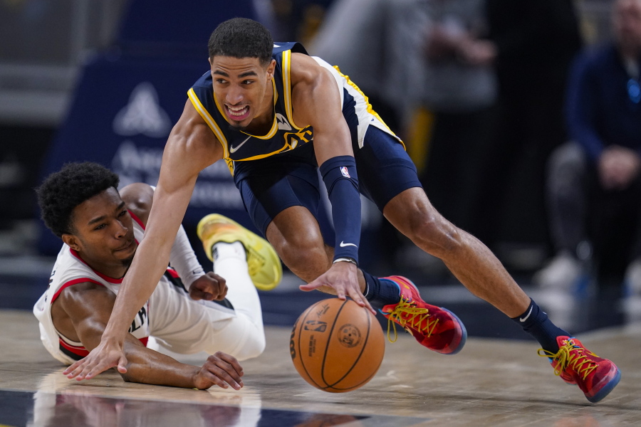 Indiana Pacers guard Tyrese Haliburton, right, and Portland Trail Blazers guard Brandon Williams, left, go for the ball during the first half of an NBA basketball game in Indianapolis, Sunday, March 20, 2022.