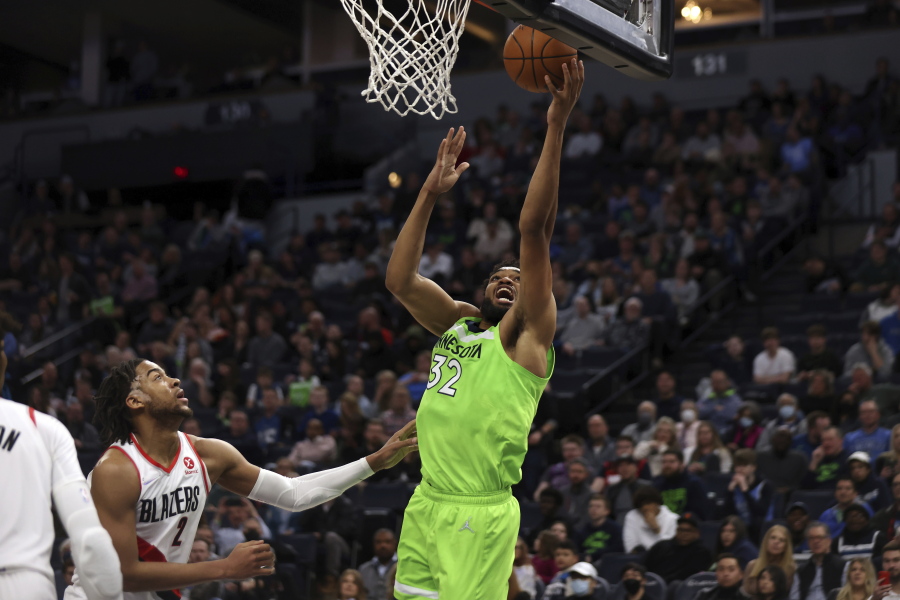 Minnesota Timberwolves center Karl-Anthony Towns (32) shoots next to Portland Trail Blazers forward Trendon Watford (2) during the first half of an NBA basketball game Saturday, March 5, 2022, in Minneapolis.