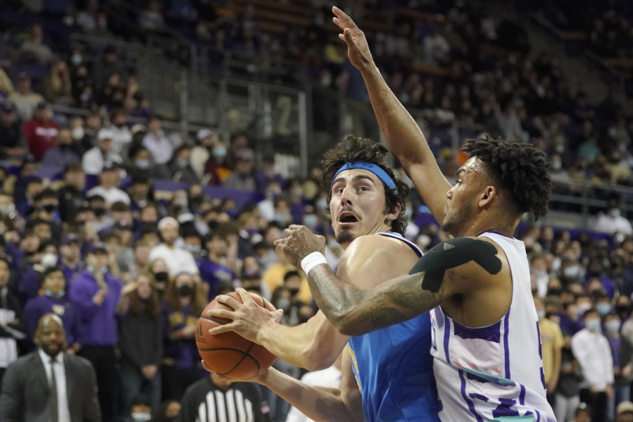 UCLA guard Jaime Jaquez Jr., left, is guarded by Washington guard Jamal Bey, right, during the first half of an NCAA college basketball game, Monday, Feb. 28, 2022, in Seattle. (AP Photo/Ted S.