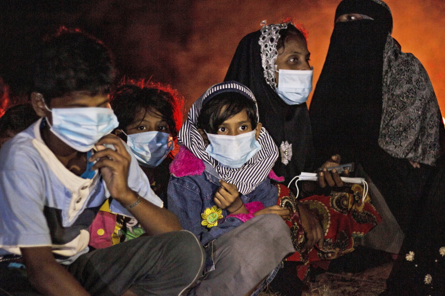 Ethnic Rohingya women and children sit by a fire on a beach after their boat was stranded on Idaman Island in East Aceh, Indonesia, late Friday, June 4, 2021, after leaving a refugee camp in Bangladesh, officials said. U.S. officials say the Biden administration intends to declare that Myanmar's years-long repression of the Rohingya Muslim population is a "genocide." Two officials say Secretary of State Antony Blinken plans to announce the long-anticipated designation on Monday, March 21, 2022.