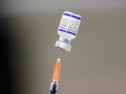 FILE - A syringe is prepared with the Pfizer COVID-19 vaccine at a vaccination clinic at the Keystone First Wellness Center in Chester, Pa., on Dec. 15, 2021. Pfizer is expected to request authorization for an additional COVID-19 booster dose for seniors.