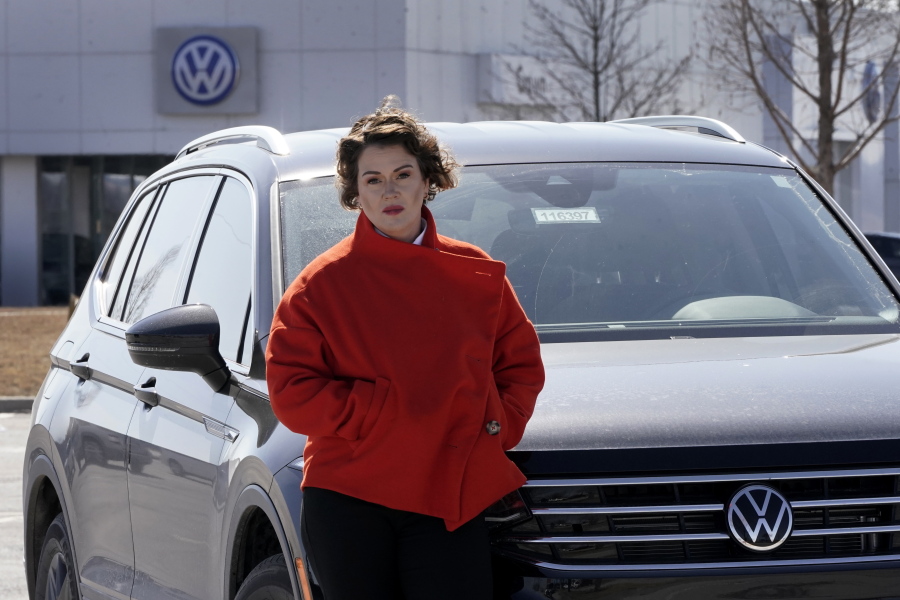Kendall Heiman stands with the loner car she has driven for the past two months, Wednesday, March 9, 2022, in Lawrence, Kan., while a dealership works to repair her Volkswagen 2021 Atlas Cross Sport after the car slammed on the brakes for no reason on Jan. 5. Heiman and a dozen other Cross Sport owners have filed complaints about the issues with the U.S. National Highway Traffic Safety Administration.