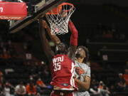 Washington State forward Mouhamed Gueye dunks in front of Oregon State forward Ahmad Rand during the second half of an NCAA college basketball game on Monday, Feb. 28, 2022, in Corvallis, Ore. Washington State won 103-97.