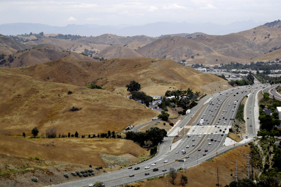 FILE - U.S. Highway 101 passes between two separate open space preserves on conservancy lands in the Santa Monica Mountains in Agoura Hills, Calif., July 25, 2019. Groundbreaking is set for next month on what will be the world's largest wildlife crossing, a bridge over a major Southern California highway that will provide more room to roam for mountain lions and other animals hemmed in by urban sprawl. A ceremony marking the start of construction for the span over U.S. 101 near Los Angeles will take place on Earth Day, April 22, the National Wildlife Federation announced on Thursday, March 24, 2022.