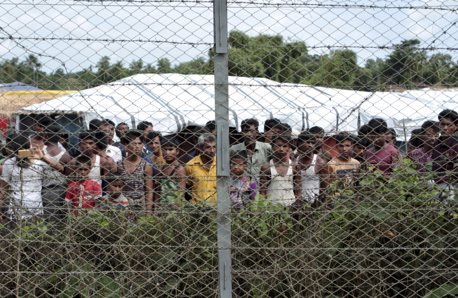 FILE - Rohingya refugees gather near a fence during a government organized media tour, to a no-man's land between Myanmar and Bangladesh, near Taungpyolatyar village, Maung Daw, northern Rakhine State, Myanmar, June 29, 2018. An international case accusing Myanmar of genocide against the Rohingya ethnic minority returns to the United Nations' highest court Monday, Feb. 21, 2022, amid questions over whether the country's military rulers should even be allowed to represent the Southeast Asian nation.