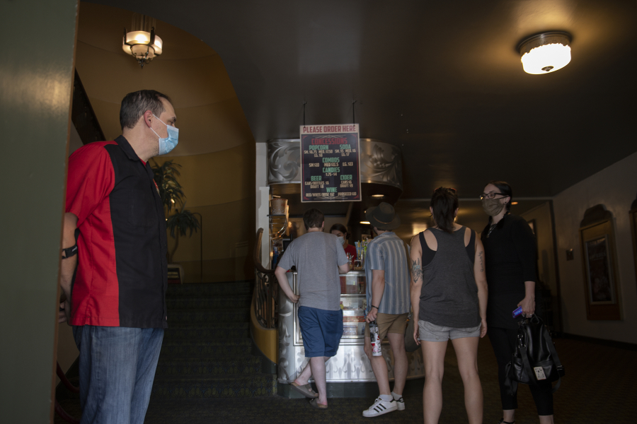 Kiggins Theatre owner Dan Wyatt, left, welcomes back moviegoers in June after pandemic closures.