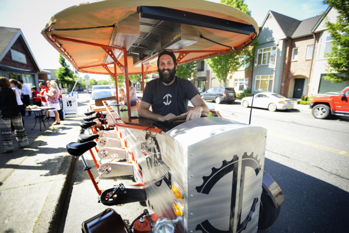 Michael Palensky, owner of the Couve Cycle, a 14-passenger pedal powered party cycle, sits in the driver's seat during the Chamber of Commerce's Small Business Crawl in Uptown Village on May 11, 2016. Palensky is now selling the company for $50,000 and is hoping to find a local buyer.