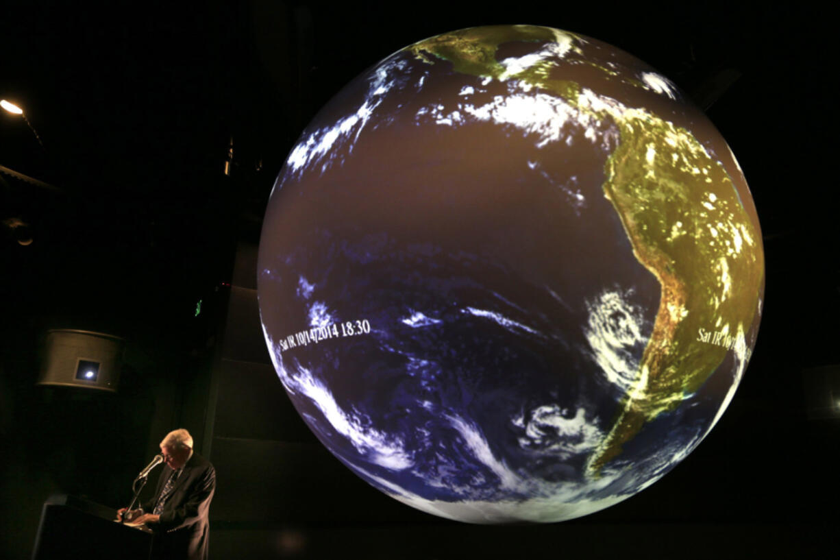 Aquarium Of The Pacific President Dr. Jerry Schubel gathers his notes prior to a discussion on the El Nino weather phenomenon at the Aquarium Of The Pacific in Long Beach, California, while projecting images of the weather patterns on their Science On A Sphere exhibit, Nov. 13, 2014.