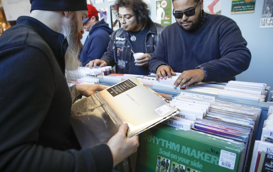 Customers shop for special edition vinyl records at Dusty Groove music store April 13, 2019, during the Record Store Day in Chicago.