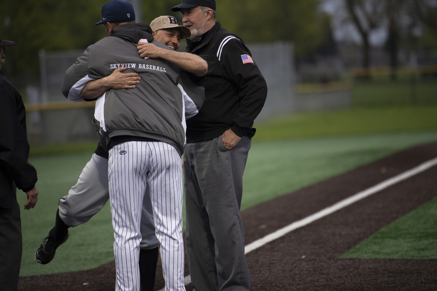 Battle Ground coach Billy Hayes embraces Skyview coach Seth Johnson prior to their teams? 4A Greater St. Helens League baseball game at Propstra Stadium on Monday, April 25, 2022.