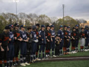 Players from the Battle Ground and Skyview baseball teams stand arm in arm in a show against discrimination prior to their game at Propstra Stadium on Monday.