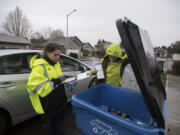 Jerin Dinkins, left, and Gina Evans, recycling specialists with Waste Connections of Washington, look for items that cannot be recycled while on their route in northeast Vancouver in January 2020.