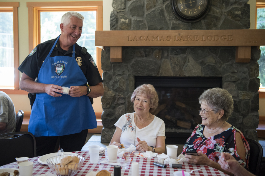 Camas Police Chief Mitch Lackey, from left, hands out ice cream to Irene Cole and Carrie Glaser, both of Vancouver, during the Seniors and Law Enforcement Together annual picnic at the Lacamas Lake Lodge in Camas on July 23, 2018.