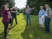Local residents gather outside the home of Dean Hergesheimer, center, to discuss the possibility of a road connecting Northeast 174th and Northeast 179th streets.
