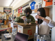 Union High School freshmen Victor Vitorino, left, and Savannah Lee pack a box full of water bottles and bowls Thursday at Union High School. The pair are two of hundreds of students participating in an after-school STEM Academy that leads simple experiments for young children in Evergreen Public Schools as a way to garner interest in science and math at a young age.