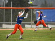 Ridgefield freshman Charlie Harris, left, catches the ball Friday, April 1, 2022, during the Spudders' 10-1 win against R.A. Long at Ridgefield High School.