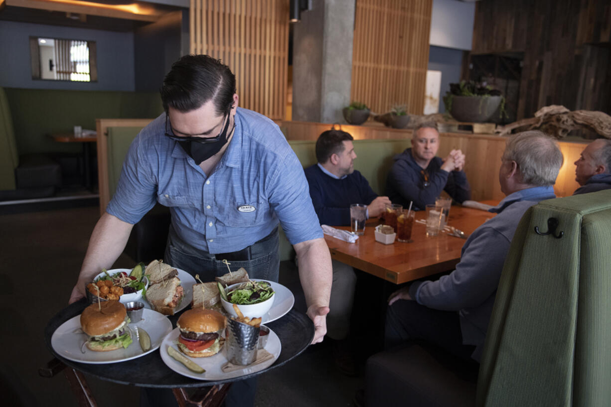 Server Aaron Snoddy, from left, serves lunch on Thursday to Mark Ritzheimer, Gary Kercheck, Steve Peters and Scott Hampton at Grays Restaurant & Bar. Lunch is now served daily at Grays in the Hilton Vancouver Washington.