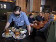 Server Aaron Snoddy, from left, serves lunch on Thursday to Mark Ritzheimer, Gary Kercheck, Steve Peters and Scott Hampton at Grays Restaurant & Bar. Lunch is now served daily at Grays in the Hilton Vancouver Washington.