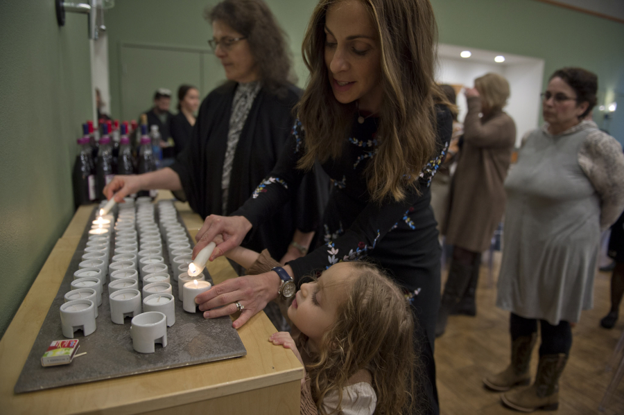 Tzivie Greenberg, and her daughter, Kenya, 4, light candles for the start of Passover ceremonies at a Passover Seder held Friday evening at  at Chabad Jewish Center of Clark County.