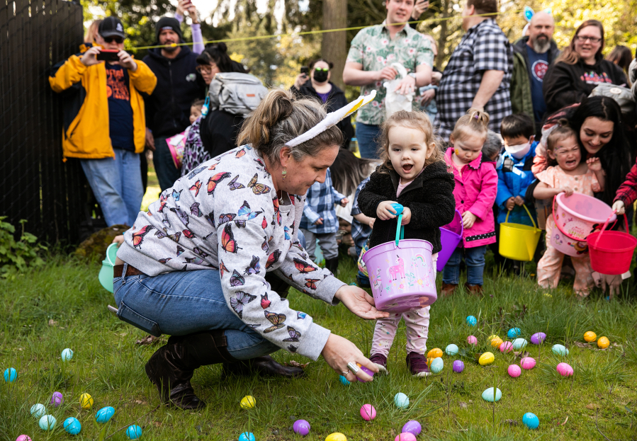 Emily Edwards of Vancouver helps her daughter Evette Edwards, 2, collect goodies during Saturday afternoon's annual Easter egg hunt at Vancouver Elks Lodge No. 823. Evette's age group, while competitive, was a tad less high-energy than the older groups. An estimated 200-plus children took part in the event, pursuing 2,400 eggs.